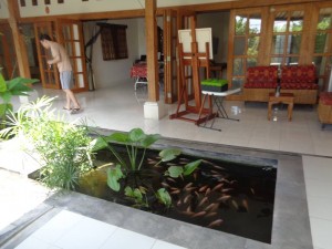 Front of house has gallery terrace and fish pond